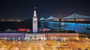 Ferry Building Jeep tour at sunset with San Francisco skyline and city lights beginning to sparkle