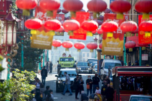 Open-air Jeep driving down Grant Avenue in San Francisco’s Chinatown with red lanterns overhead