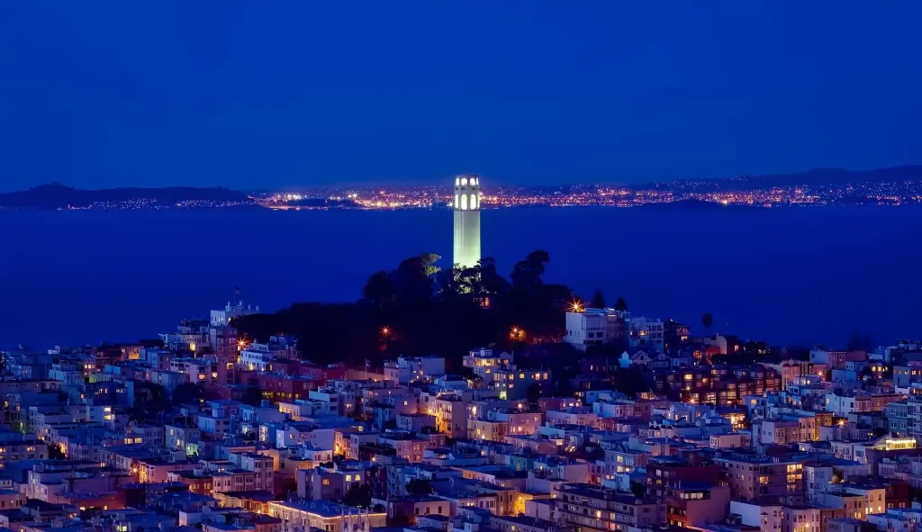 Coit Tower and Telegraph Hill illuminated at night during a San Francisco sunset or city lights Jeep tour