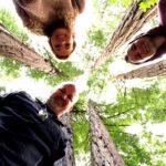 Group taking a selfie in Muir Woods National Park surrounded by towering giant redwood trees