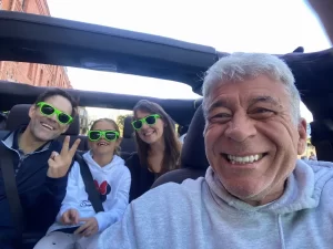 Tour guide Jo-Jo and a family of three taking a selfie inside an open-air Jeep before a San Francisco sightseeing tour