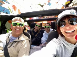 our guide Katya and three guests smiling and taking a selfie inside an open-air Jeep during a San Francisco sightseeing tour
