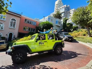 Open-air Jeep sightseeing tour driving down Lombard Street, the Crookedest Street in San Francisco