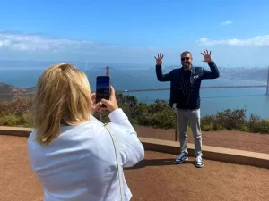Couple posing for a photo with the Golden Gate Bridge in the background during a San Francisco Jeep sightseeing tour