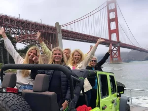 Five guests riding in an open-air Jeep at the Golden Gate Bridge during a San Francisco sightseeing tour