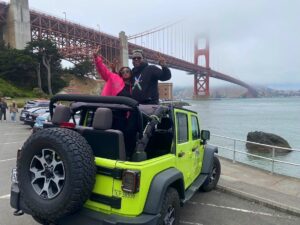 Guests near the historic Fort Point with fog drifting around the Golden Gate Bridge during a San Francisco Jeep sightseeing tour