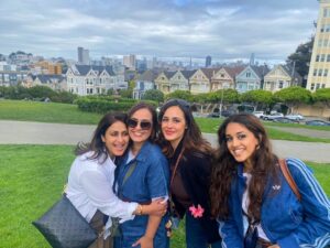 Four tour guests posing near the Painted Ladies at Alamo Square Park during a San Francisco Jeep sightseeing tour